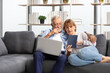 © offsuperphoto - senior couple using laptop computer and tablet on sofa