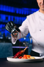 The Chef Pours Sauce On The Duck Leg Dish In The Restaurant Hall.
