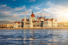 View Over The River Danube To The Impressive Hungarian Parliament Building In Budapest During Golden Sunset Time