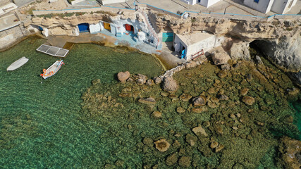 Wall Mural - Aerial drone photo of picturesque small fishing harbour of Mandrakia with traditional boat houses called syrmata and anchored fishing boats, Milos island, Cyclades, Greece