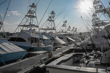 White Boats For Recreation And Fishing In The Marine Parking Lot Illuminated By The Bright Sun.