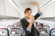 © Kostiantyn - Female stewardess demonstrating how to use oxygen mask in plane