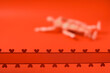 Red ribbon with hearts in focus. Couple making love out of focus. Juicy red background. Adult scene. Abstract sex concept. Close contact between lovers. Wooden mannequin as a models.