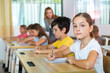 © JackF - Kids studying in classroom. Girl sitting at desk and looking in camera.