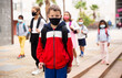 © JackF - Confident tweenager in protective mask walking with other schoolchildren to school campus after lessons on spring day. Concept of necessary precautions in COVID pandemic