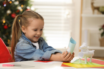 Poster - Cute little girl with paper Saint Nicholas toy at home