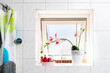 Modern white bathroom tiles tiled wall with shower curtain open window and sunny bright natural sunlight light and potted colorful orchid flower decoration in domestic home interior design