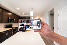 Hand Photographing House Apartment Kitchen Island Room For Sale Or Rent With Phone Smartphone Closeup Point Of View In Modern Luxury Condo Home With Blurry Bokeh Background