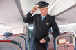 © Kostiantyn - Man aircraft pilot standing in passenger airplane salon