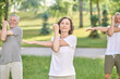 © zinkevych - People having a yoga class in the park and stretching their arms