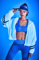 Wall Mural - Ready for a workout. Cropped shot of an attractive young female athlete posing against a blue background.