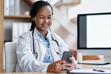 She welcomes texts from her patients. Shot of a young doctor using a cellphone while working in her office.