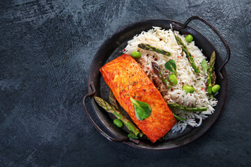 Wall Mural - Baked salmon with rice and asparagus on gray background.