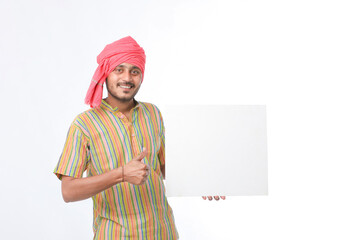 Young indian farmer holding white card board on white background.