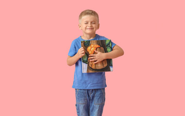 Poster - Adorable little boy with book on pink background