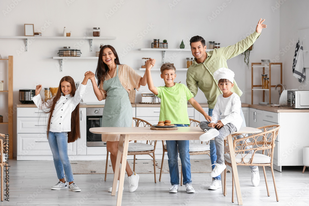 Happy  family dancing in kitchen