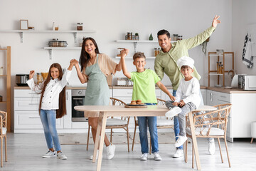 Happy  family dancing in kitchen