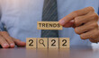 © witsarut - 2022 trend concept.business idea over wooden cube.Businessman holding wooden with year 2022 plans and copy space.