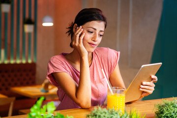 Wall Mural - Portrait og happy woman using digital tablet for work, study or social media. People technology