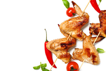 Grilled chicken wings skewers with vegetables on white background