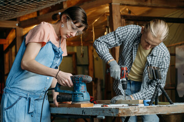 Man and woman working in workshop, doing furniture, reuse old materials to new product. awareness in consumption. Small family business. Recycling, sustainability refurbishments maintenance for home