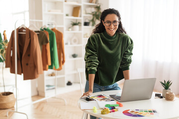 Happy Clothing Designer Lady Using Laptop Smiling Standing In Showroom