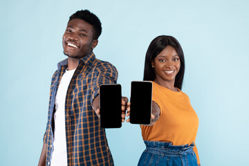 Black couple showing two blank empty smartphones screen for mockup