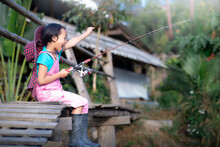 Happy A Little Girl Sitting And Catching A Fish, Lonely Happy Little Child Fishing.