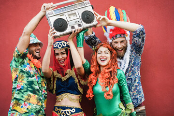 Wall Mural - Happy dressed friends celebrating at carnival party with boombox stereo outdoor - Main focus on right man face