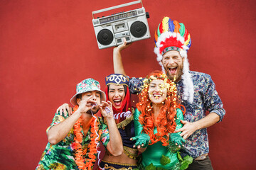 Wall Mural - Happy dressed people celebrating at carnival party throwing confetti - Main focus on right girl face