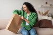 © Prostock-studio - Joyful Customer Woman Unpacking Package After Successful Shopping At Home
