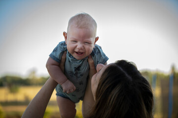 Niño bebé riendo en brazos de su madre