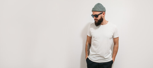 Wall Mural - Young bearded hipster guy wearing white blank t-shirt. Mock-up for print. T-shirt template.