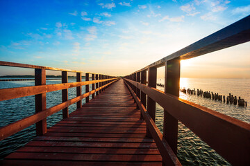 Sunrise and beautiful sky background at wooden red bridge over the sea at Gulf of Thailand, near by Tha Chin estuary, Samutsakhon province, Thailand 