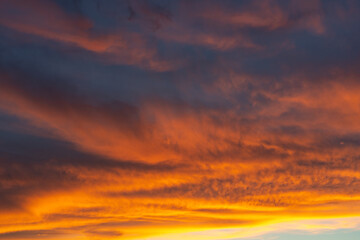 Wall Mural - During sunset, these clouds are beautifully lit from below, creating a beautiful color spectacle with yellow, orange, blue and red colors