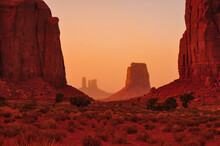 Hazy Red Sunset View Of The North Window, Between Elephant Butte And Cly Butte, Towards East Mitten Butte And Other Spires And Towers Of Monument Valley Navajo Tribal Park, Arizona, Southwest USA