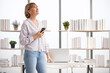 © offsuperphoto - senior woman using smartphone for work and looking up to something