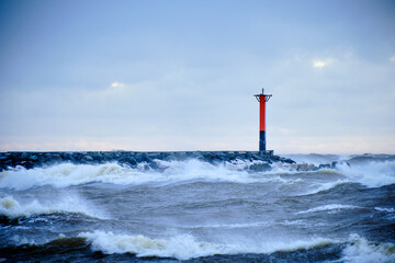 lighthouse on a windy storm on a baltic sea at winter with clouds in the sky