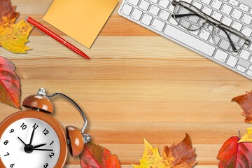 Wall Mural - Office desktop with keyboard, alarm clock with autumn leaves