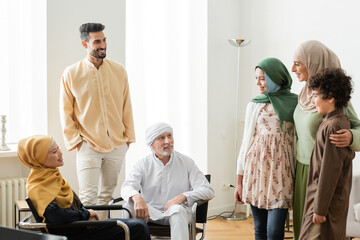 Wall Mural - smiling arabian woman hugging kids near multiethnic muslim family at home.