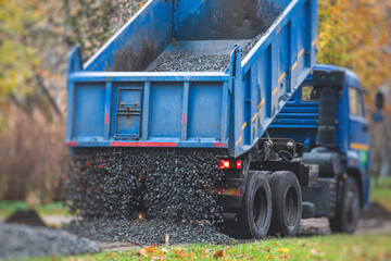 Wall Mural - Dump truck, tractor and bulldozer unloading gravel, road metal, rubble and crushed stone cement material during landscaping improvement and new pedestrian walk road construction site