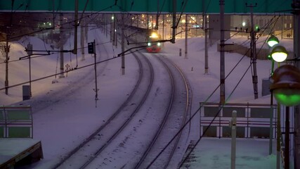 Wall Mural - Сommuter train traffic at night, in the snowfall