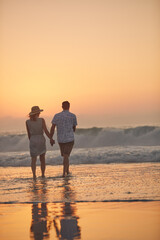 Canvas Print - Let's get wet and wild. Rearview shot of a mature couple spending quality time on the beach.