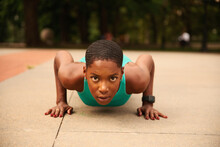 Athlete Woman In Sports Clothing Doing Push-ups In Park