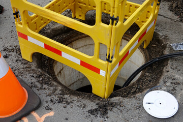 road crew working underground installing cable through a manhole