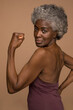 © Cultura Creative - Portrait of senior woman flexing muscles
