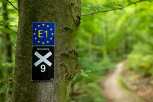 Close-up Of The Trail Marking Signs For The “E1 European Long Distance Path” And The “X9 Emmerweg” At A Hiking Trail Near Aerzen, Weser Uplands, Lower Saxony, Germany