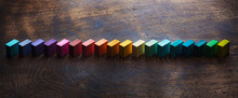 Colored Wooden Blocks Diagonally Aligned On Old Vintage Wooden Table. For Something With Concept Of Variations Or Diversity. Plenty Of Copyspace For Cover / Header Image Usage. Shallow Depth Of Field.