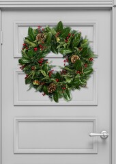 Poster - Christmas wreath with toys on a white wooden door. New year and christmas concept