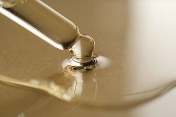 Pipettes with oil or serum on a golden background.